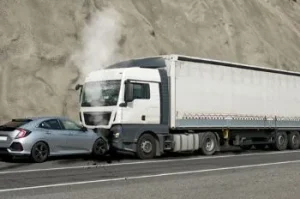 head on collision between small car and a large semi truck
