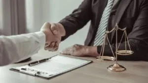 Man involved in a Nashville motorcycle accident meeting with his lawyer at his desk shaking hands