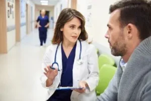 man injured in a slip and fall talking with doctor and then a Nashville slip and fall lawyer about a slip and fall lawsuit