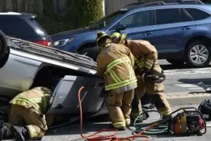 A car crash in Nashville with one of the cars rolling over and emergency crew working to get out