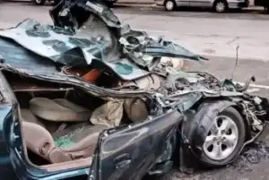 demolished green compact car after a Nashville car accident, a very bad Nashville car crash, to illustrate effect.