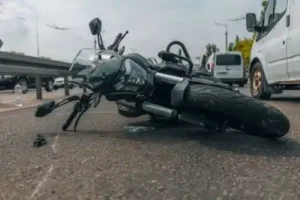Picture of a motorcycle crash in Nashville, black motorcycle on its side by white van causing crash