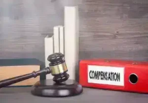 Compensation. Wooden gavel and books in background. Law and justice concept