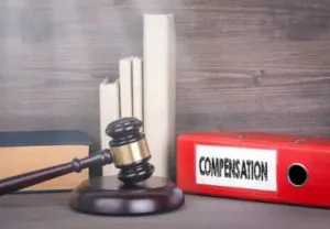 Compensation. Wooden gavel and books in background. Law and justice concept