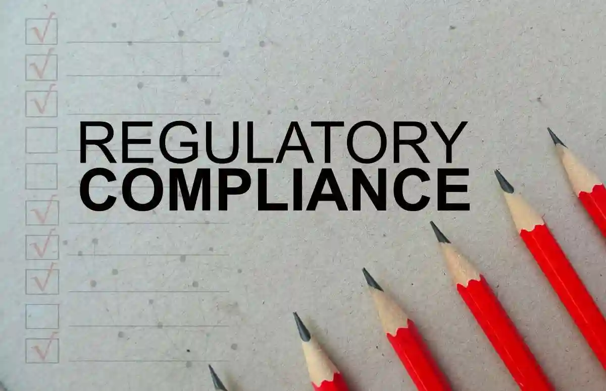 Word text Regulatory Compliance memo written on a brown craft paper as background with red pencils used in Embezzling Receipts and Securities Litigation