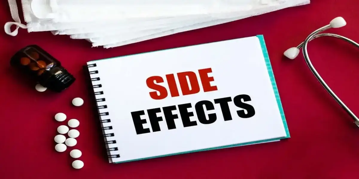 side effects in red and blackk on red table next to a stethoscope used in Dupixent and Cancer,