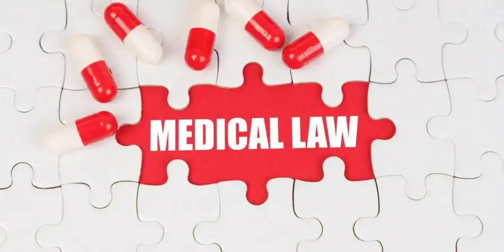 Medical concept. There are pills on the white puzzles, in the middle there is a red surface with the inscription - MEDICAL LAW used in Nashville Infant Brain Injury Lawyer