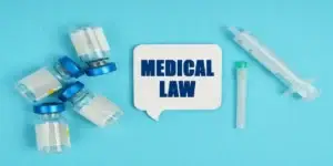 words "medical law" in blue on white background next to medical equipment all on light teel background image in eligible for a Mounjaro Stomach Paralysis Lawsuit,