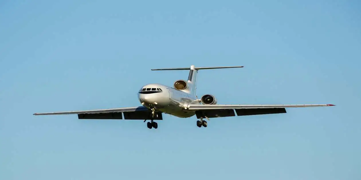 sliver large passenger airplane fying in a beautiful day with blue sky and no clouds used in Aircraft Toxic Fume Exposure