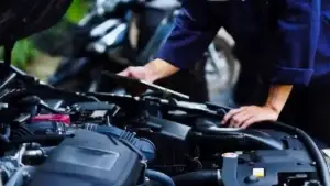 Mechanic in work gloves repairs car engine in auto repair shop. Auto mechanic checks vehicle with wrench, fixes issues. Car service, maintenance, engine diagnostic, automotive repair. used in Faulty Faulty GM Transmission Issues