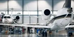 Maintenance of airplane in large white hangar. Modern private jet at the factory used in Symptoms of Aerotoxic Syndrome