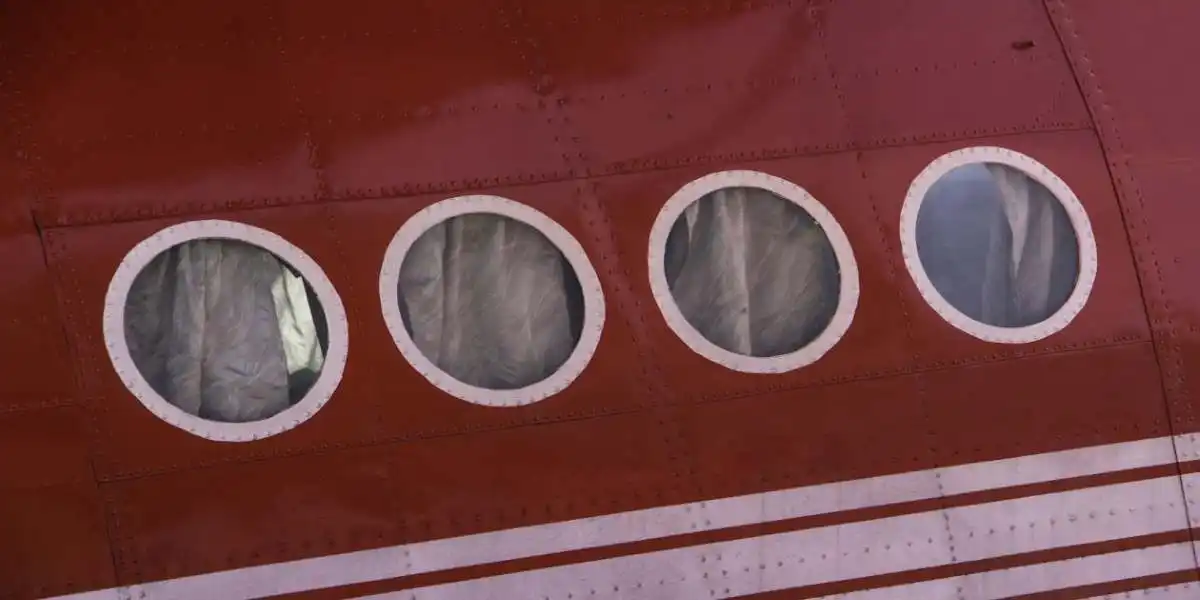side of red pasenger plane on ground used in exposure to a fume event