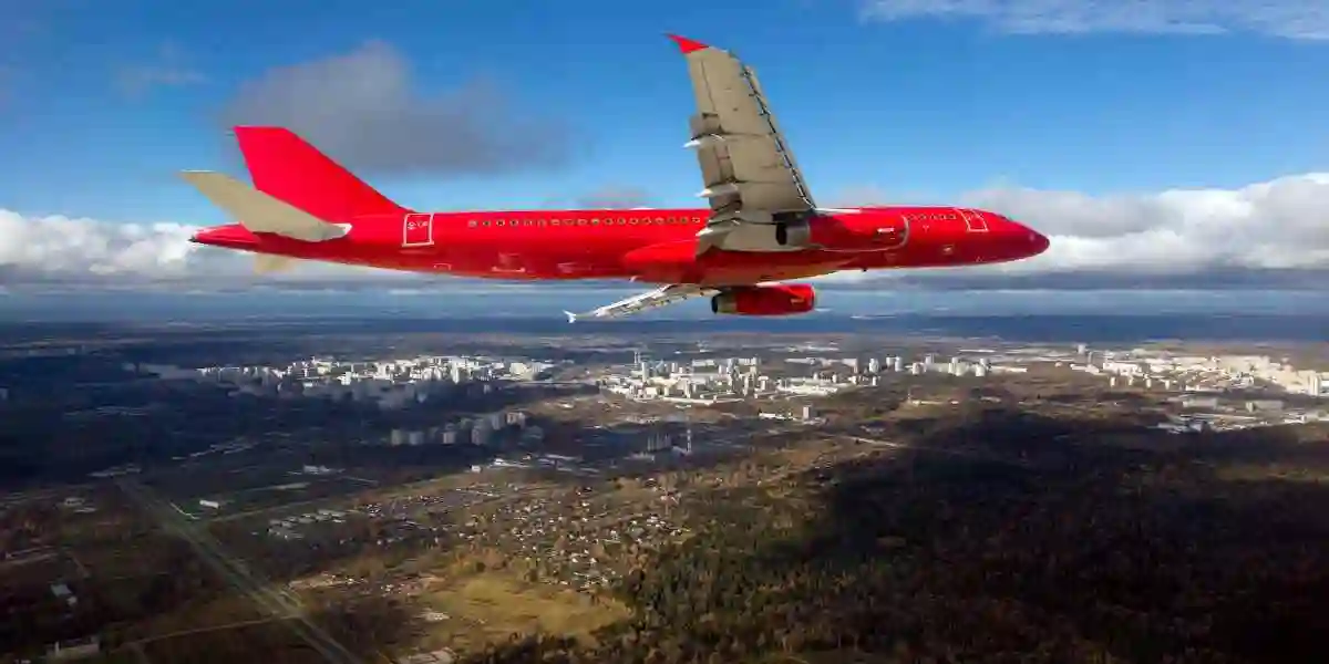 red passenger airliner maker a turn  on a sunnday day used in Toxic Airplane Cabin Fumes