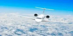 white passenger plane flying above clouds on nice day in fume event lawsuits