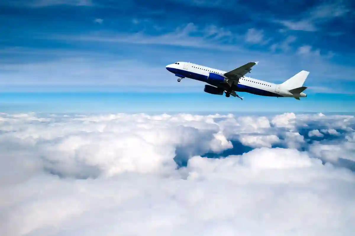 Airplane in the flight, white commercial airplane flying high over the floating clouds, flying airplane background used in Symptoms of Aerotoxic Syndrome