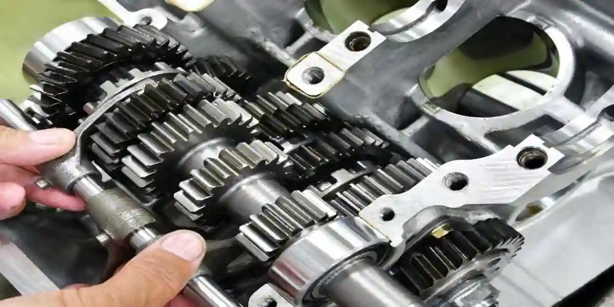 man working on a brand new silver transmission outside in yard