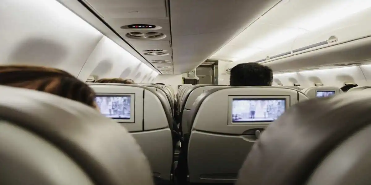 plane cabin in flight with passengers watching tv and used in exposure to toxic plane fumes
