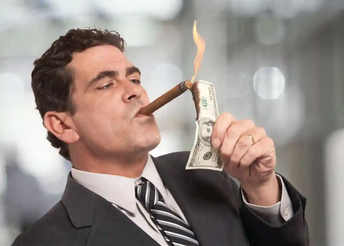 Rich businessman lighting cigar with $100 dollar bill USED IN ZEPBOUND AND EYE STROKE