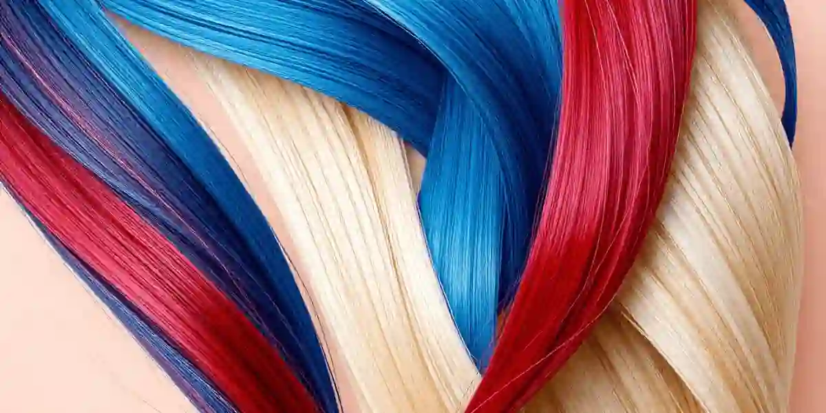Close-up of vibrant red, blue, and blonde hair strands artistically arranged with subtle abstract legal scales on a soft neutral background.  Compensation in a Hair Dye Lawsui