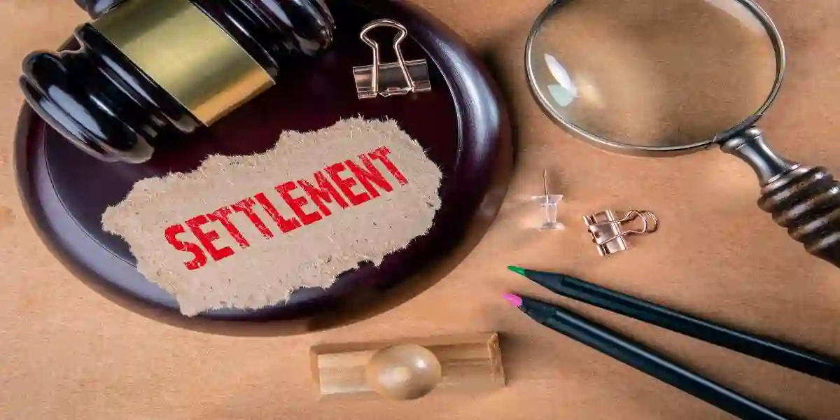 SETTLEMENT. Laws, litigation, lawyers and compromise concept. Wooden court hammer and magnifying glass on the table used in Compensation in a Tennessee Hair Dye Lawsuit 
