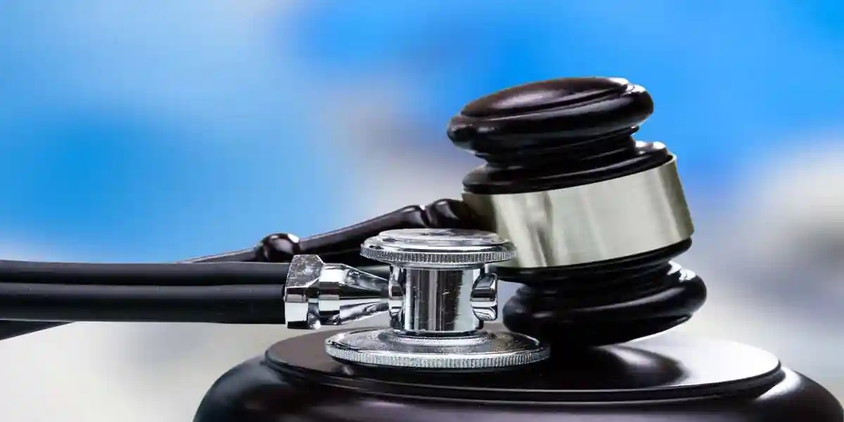 Close-up of a judge’s gavel resting beside a medical stethoscope, symbolizing the intersection of law, healthcare, medical ethics, and legal responsibility.
