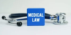 Medicine and health concept. On the table is a stethoscope and a blue cube with the inscription - MEDICAL LAW