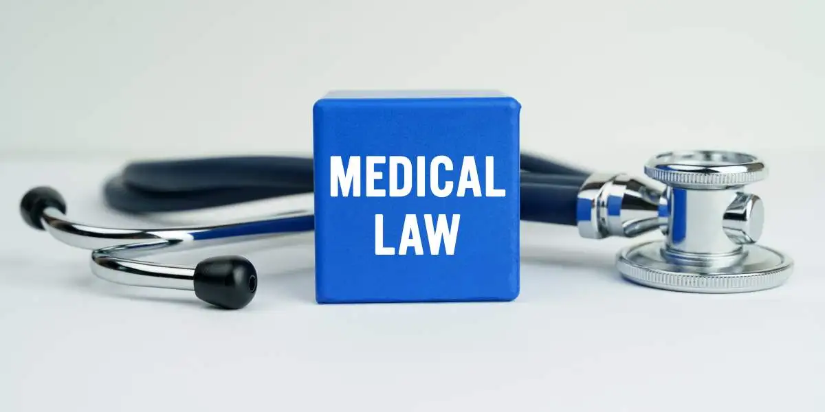 Medicine and health concept. On the table is a stethoscope and a blue cube with the inscription - MEDICAL LAW